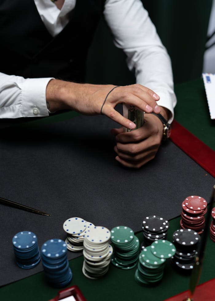 Close-up of a person handling money and poker chips at a casino table.