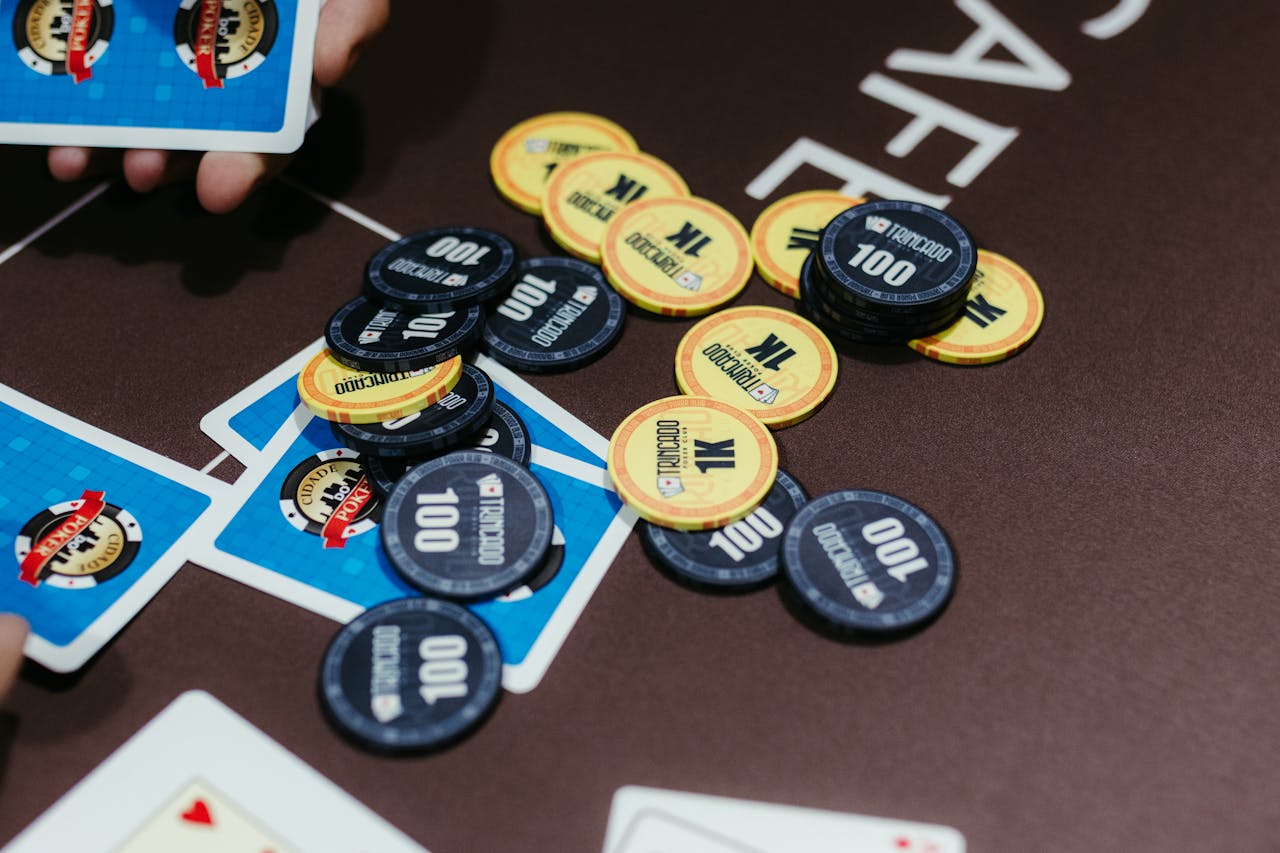 About A close-up of poker chips and cards on a table during a game of Texas Holdem.